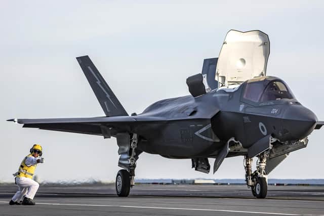 Pictured right is Lieutenant Commander Richard 'Ritchie' Turrell, 45, flight deck officer on HMS Queen Elizabeth. He is pictured directing an F-35B stealth jet on Queen Elizabeth's flight deck in Florida. Image: Royal Navy/LPhot Kyle Heller