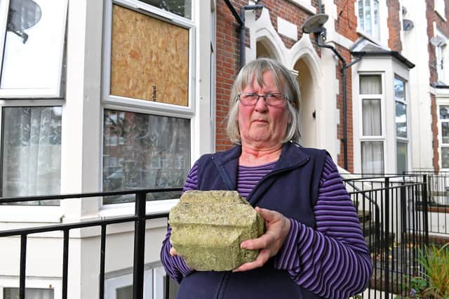 Pictured is Sue Forrest holding the large piece of masonry that was thrown through her flat window.
Picture: Malcolm Wells (191016-8473)