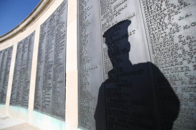 The shadow of a Royal Navy rating falls on the names on one of the panels on the Portsmouth Naval memorial in Southsea. Picture: Andrew Matthews/PA Wire