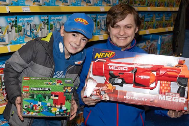 Lucas Gilkes with store assistant Charlie Cook with some of his purchases. Lucas received a 50 gift card for being first in the queue. Picture: Keith Woodland (091119-46)