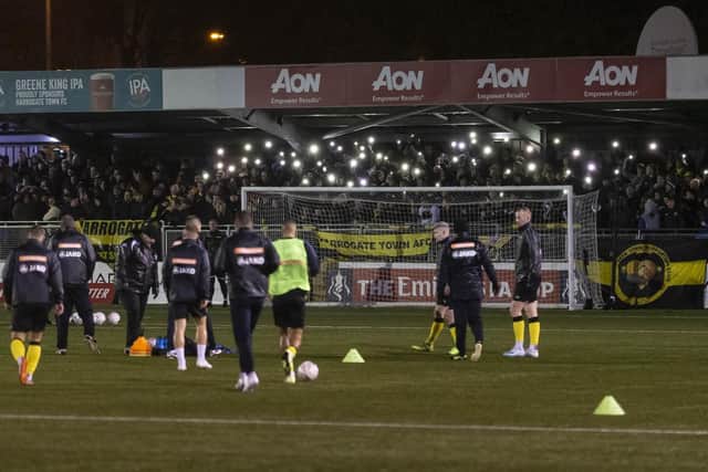 Harrogate Town fans hold their phones up as torches as the power goes out at Wetherby Road Picture: Daniel Chesterton