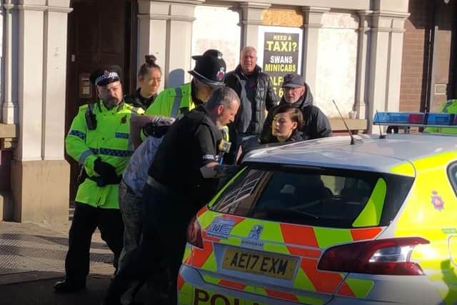 A man is bundled away by police  to protect him from the angry after he disrupted a silent tribute with fireworks at a Remembrance Sunday event at the cenotaph in Eccles, Salford. Picture: Pat Hurst/PA Wire