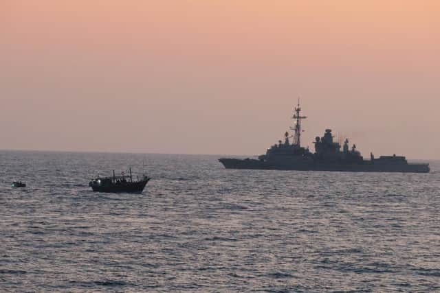 HMS Montrose pictured next to the dhow as a Royal Navy boarding party approaches. Photo: MoD/Chris Daly