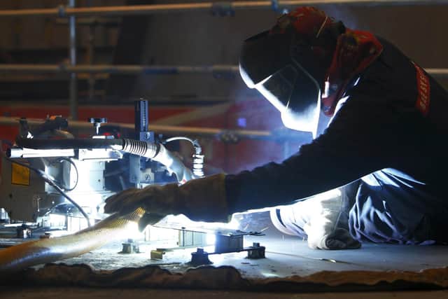 A ship builder welds a hull section of the first of two Queen Elizabeth class aircraft carriers at BAE Systems in Portsmouth on December 8, 2010. Photo: Chris Ison/PA Wire