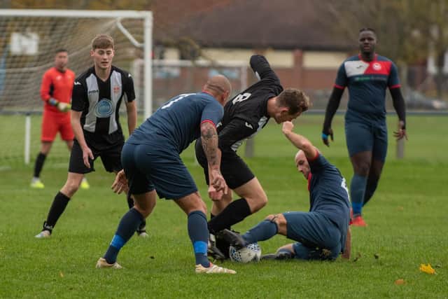 Hayling's Matt Topple is tackled by Paulsgrove's John Cripps as Aaron Fennemore looks on