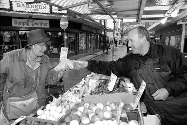 A market trader serves a customer at his stall in Charlotte Street, Portsmouth