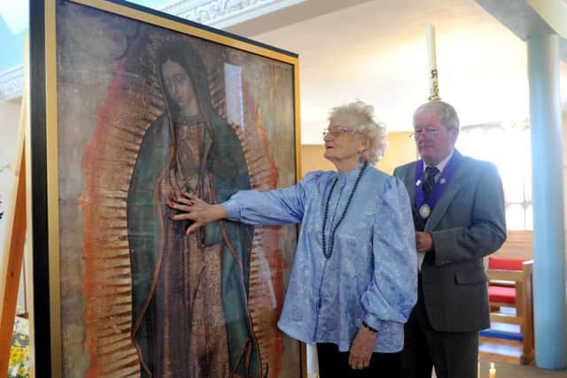 Mary Law (76) from Hayling Island, touching the Miraculous Relic Image of Our Lady of Guadelupe.  Picture: Sarah Standing (150775-6535)