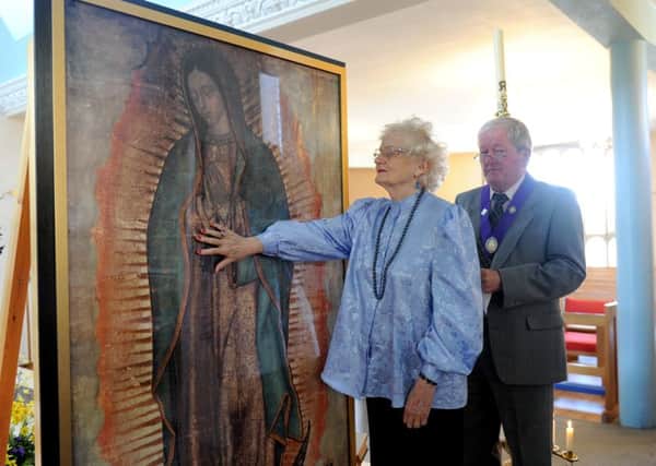 Mary Law (76) from Hayling Island, touching the Miraculous Relic Image of Our Lady of Guadelupe.  Picture: Sarah Standing (150775-6535)