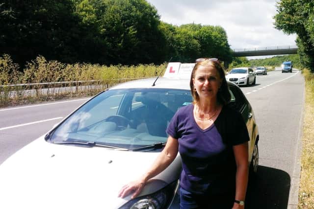 Julie Woollacott, a driving instructor, on a pothole-ridden stretch of the A27