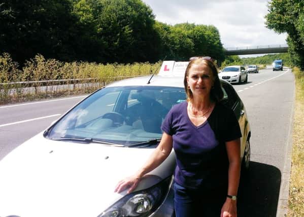 Julie Woollacott, a driving instructor, on a pothole-ridden stretch of the A27