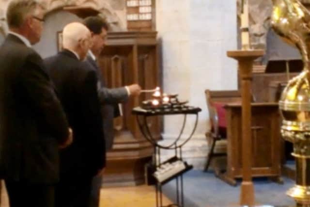 Adur District Council chairman Carson Albury lights a candle, followed by councillor Fred Lewis and East Worthing and Shoreham MP Tim Loughton