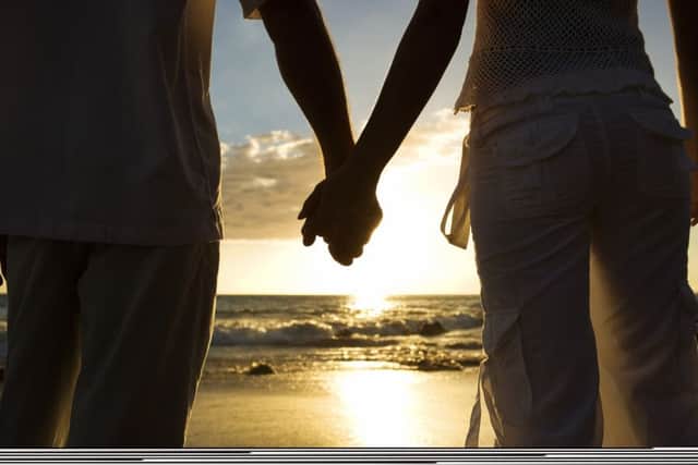 Couple holding hands on beach EMN-150202-181913001