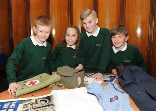 Children from Portsmouth schools learnt about the Blitz for the 75th anniversary of the bombing of the city on Monday the Portsmouth Guildhall.   Pictured is: (l-r) Liam Maddox (9), Maya Flint (10), Matthew Pilbeam (10) and Jack Chamberlain (9) from Fernhurst Junior School looking at artefacts.   Picture: Sarah Standing (160090-7846)