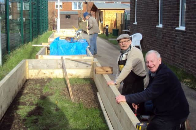 Menshed volunteers building the new raised beds