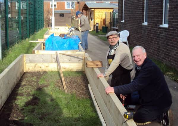 Menshed volunteers building the new raised beds
