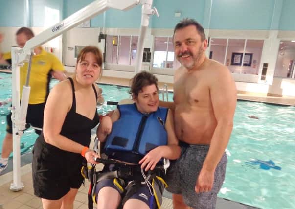 HAPPY Holly Styles in the pool hoist with her parents Gail and Mike