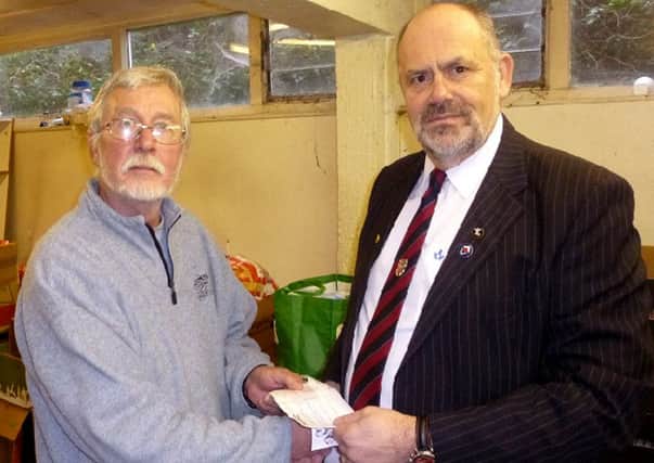 Prince of Wales Lodge member David Andrews presents a cheque for Â£400 to Clive Erricker at the Gosport Basics Food Bank