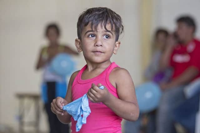 File photo of Syrian migrants being housed at a warehouse after coming ashore at RAF base Akrotiri in Cyprus,