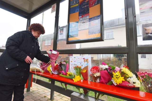 Jacqueline Howe lays flowers at the bus stop where the cat used to visit Picture: Solent News & Photo Agency UK