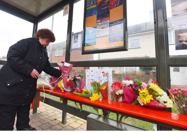 Jacqueline Howe lays flowers at the bus stop where the cat used to visit Picture: Solent News & Photo Agency UK