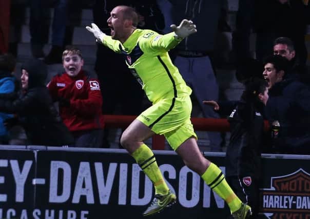 Morecambe keeper Barry Roche celebrates his late equaliser Picture: Joe Pepler