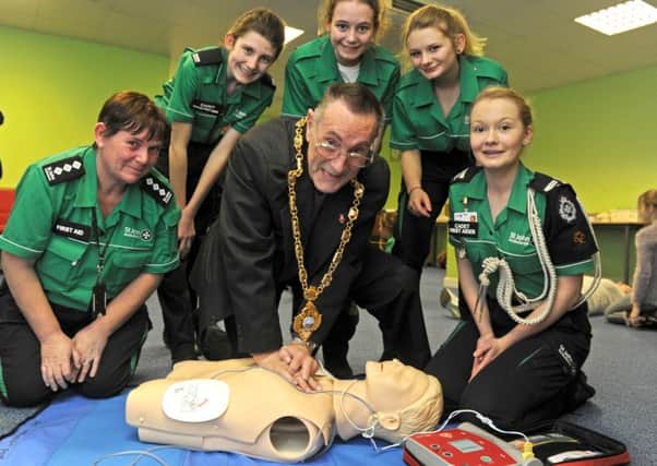 The Mayor of Gosport, Councillor Keith Farr learns CPR during a visit to the St John Ambulance headquarters in Gosport. From left, cadet manager Angie Petts, Isla Hadley, Kassia Gamble, Shannon Kikby, and Catherine Wright             
Picture Ian Hargreaves  (160172-2)