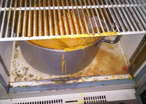 A pot of food stored in dirty conditions in rear store of Sarah Restaurant