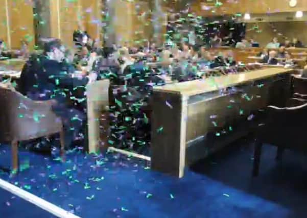 Sisters Uncut released 4,745 pieces of green and purple confetti into the council chamber, halting the budget meeting for 10 minutes
