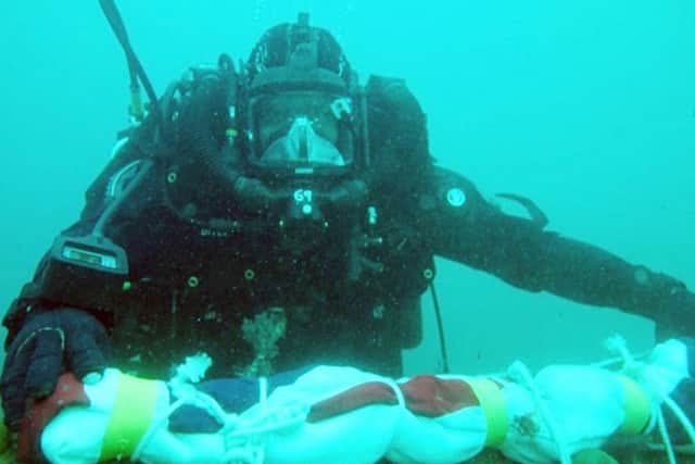 A  member of the Royal Navy's Northern Diving Group placing the White Ensign on the wreck of HMS Royal Oak, as a seven-metre torpedo found on the seabed in Scapa Flow is believed to have been fired at the ship by a German submarine at the beginning of the Second World War.  PHOTO: MoD/PA Wire
