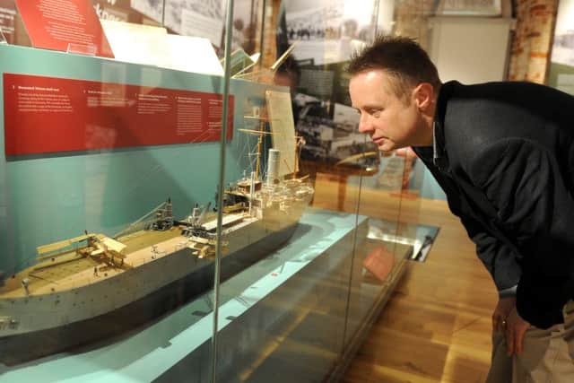 National Museum of the Royal Navy curator Nick Hewitt looking at a model of HMS Ark Royal