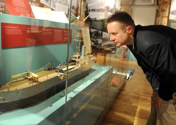 National Museum of the Royal Navy curator Nick Hewitt looking at a model of HMS Ark Royal