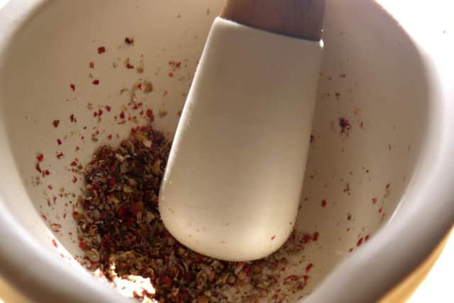 Grinding the coriander seed, pink peppercorns and sea salt