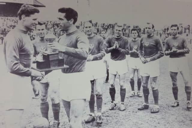 Jimmy Dickinson is presented with a trophy by Harry Harris after his last game at Fratton Park