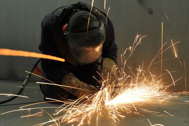 A fitter cutting steel inside the C ring of the HMS Queen Elizabeth in the shipbuilding hall a Portsmouth Dockyard