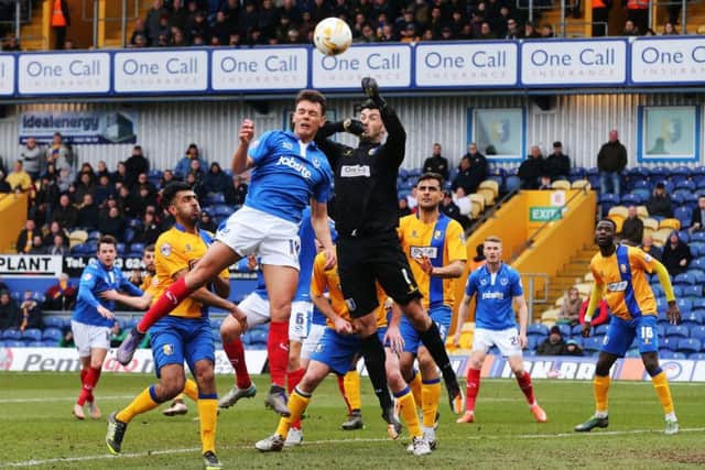 Kal Naismith challenges Mansfield keeper Scott Shearer, who saved a penalty from Marc McNulty. Picture: Joe Pepler
