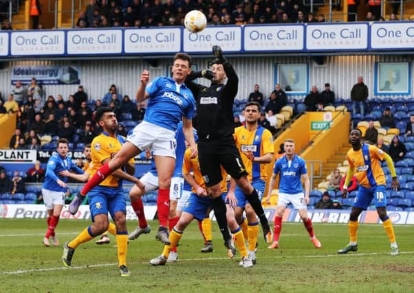 Kal Naismith challenges Mansfield keeper Scott Shearer, who saved a penalty from Marc McNulty. Picture: Joe Pepler