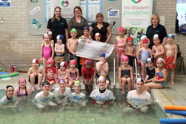 The children stand proudly by their £6000 cheque