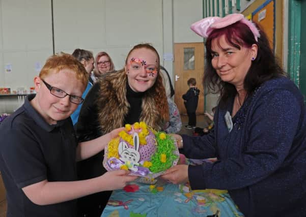 From left,  Jaydon Fewings, 11, and the Easter bonnet he made with his sister Layla-Kay Fewings, 13, and fun day helper Irene Beard.
Picture: Ian Hargreaves (160546-4)