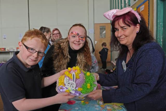 From left, Jaydon Fewings, 11, and the Easter bonnet he made with his sister Layla-Kay Fewings, 13, and fun day helper Irene Beard.
Picture: Ian Hargreaves (160546-4)