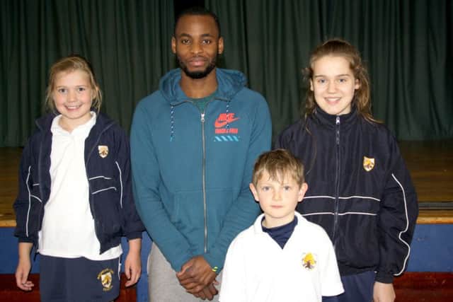 LEARNING From left: Amelia Bastian-Mason, 8, William Magro, 8, and Eva Spragg, 12, with Kola Adedoyin