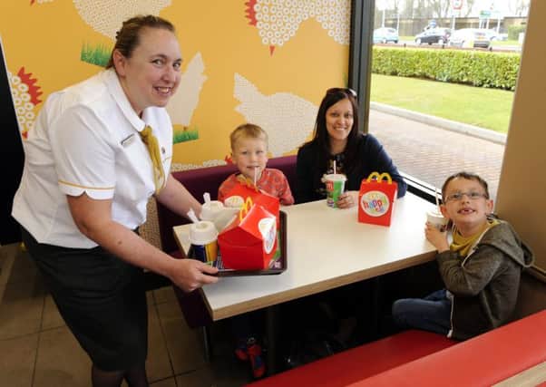 From left, admin manager Julie Norris (47), serves McDonald's customers with their order at their table (left to right) Paul Watson (5), mum Cathy Watson and Ben Watson (6)   Picture by: Malcolm Wells (160331-1754)