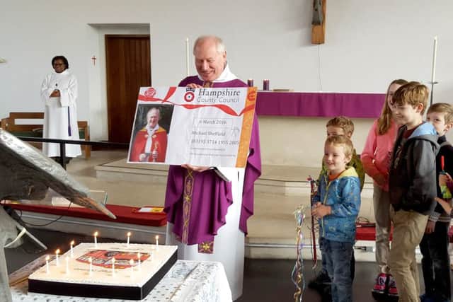 Father Mike Sheffield is presented with his giant bus pass and cake