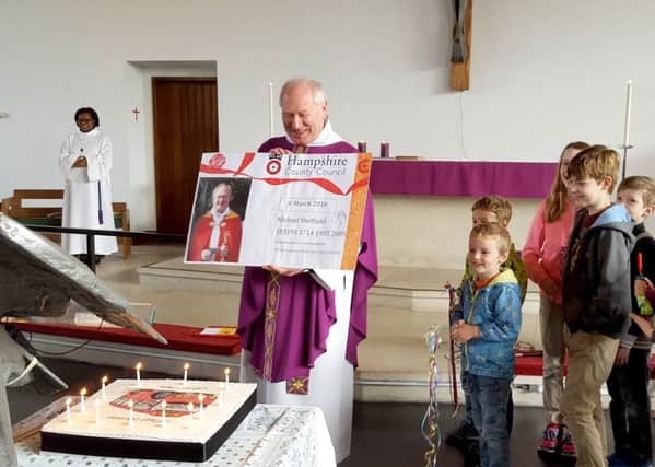 Father Mike Sheffield is presented with his giant bus pass and cake