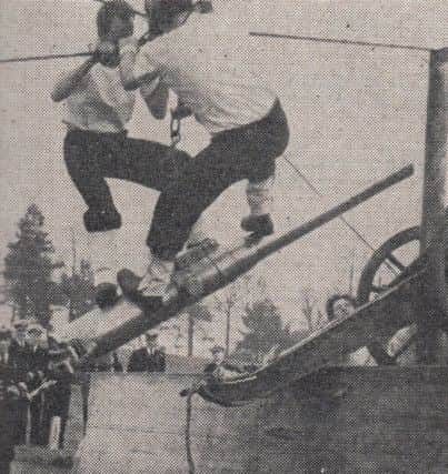 Two gunners sail across the 28 foot chasm riding on the  gun barrel.