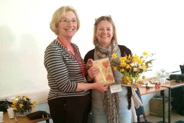 Jayne Colebourne presents Wendy Ledger with her prize for the best flower arrangement in a cup