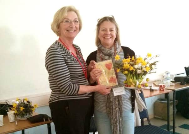 Jayne Colebourne presents Wendy Ledger with her prize for the best flower arrangement in a cup