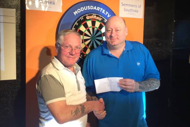 PDC player Rob Modra, right, picks up his Paulsgrove Open winnings from Pete Heather