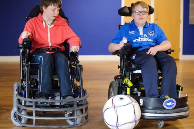 William Leaning, left, gets a football coaching session from Gregg Baxter, a Portsmouth Powerchair Football Club player Picture: Allan Hutchings (160409-097)