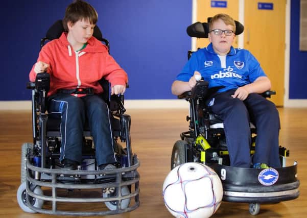 William Leaning, left, gets a football coaching session from Gregg Baxter, a Portsmouth Powerchair Football Club player Picture: Allan Hutchings (160409-097)