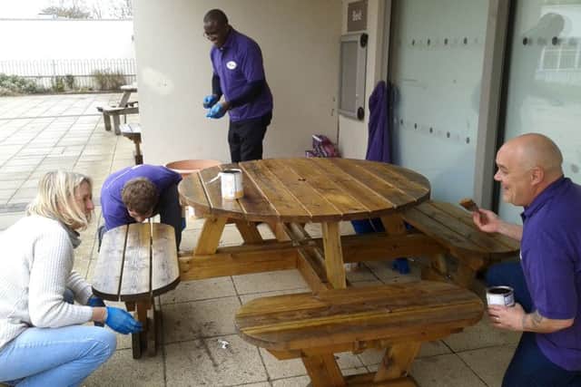 VARNISH Pfizer employees paint picnic tables at Barncroft Primary School